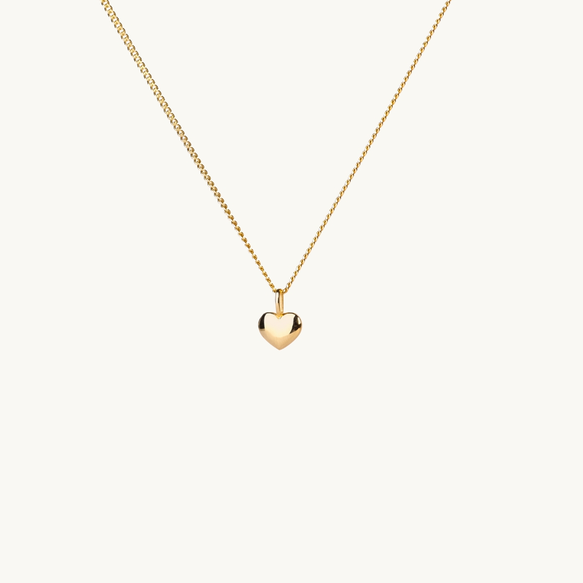 Ett halsband med ett litet fylligt guldhjrta 