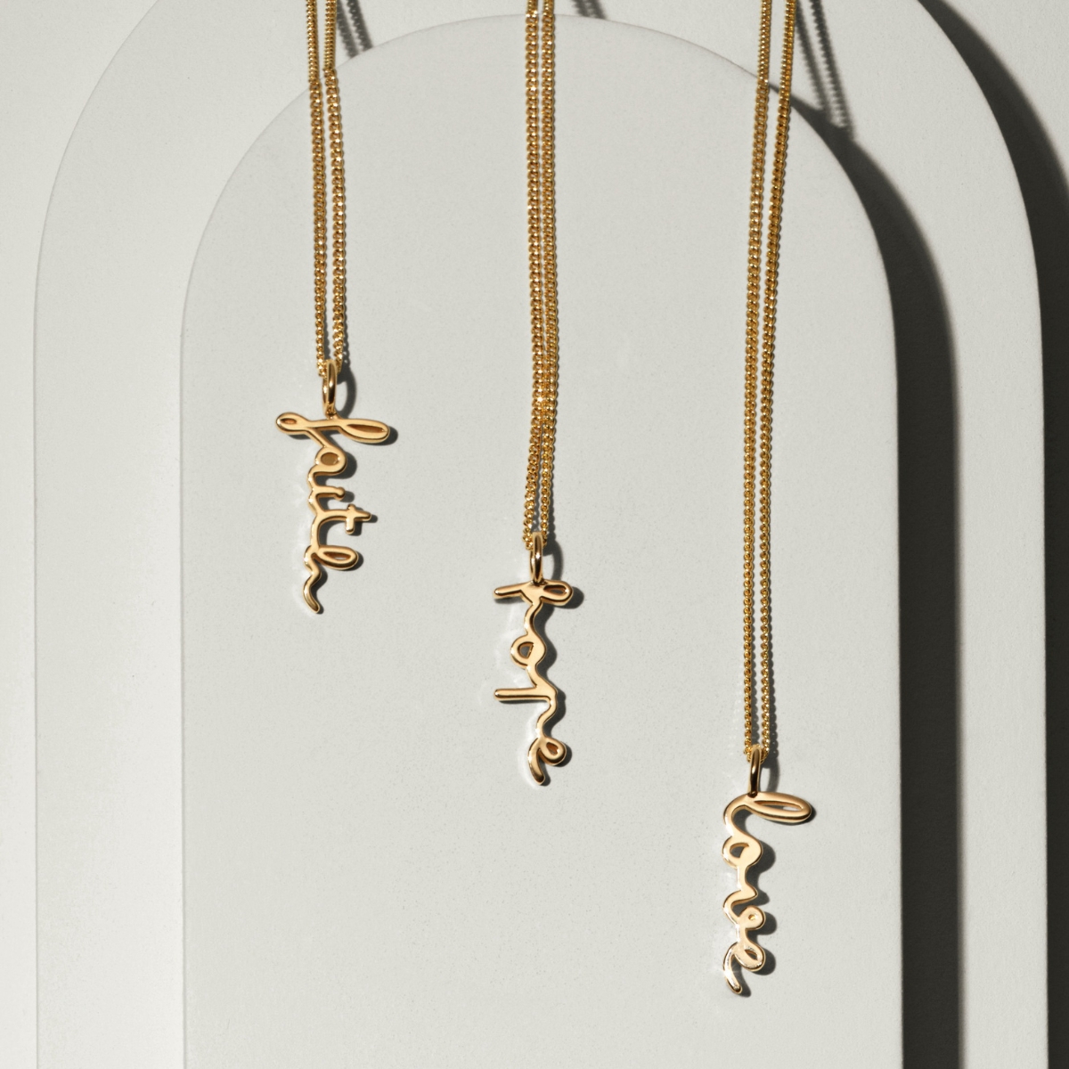 Ett 18K guldplätterat halsband i skrivstil med texten faith