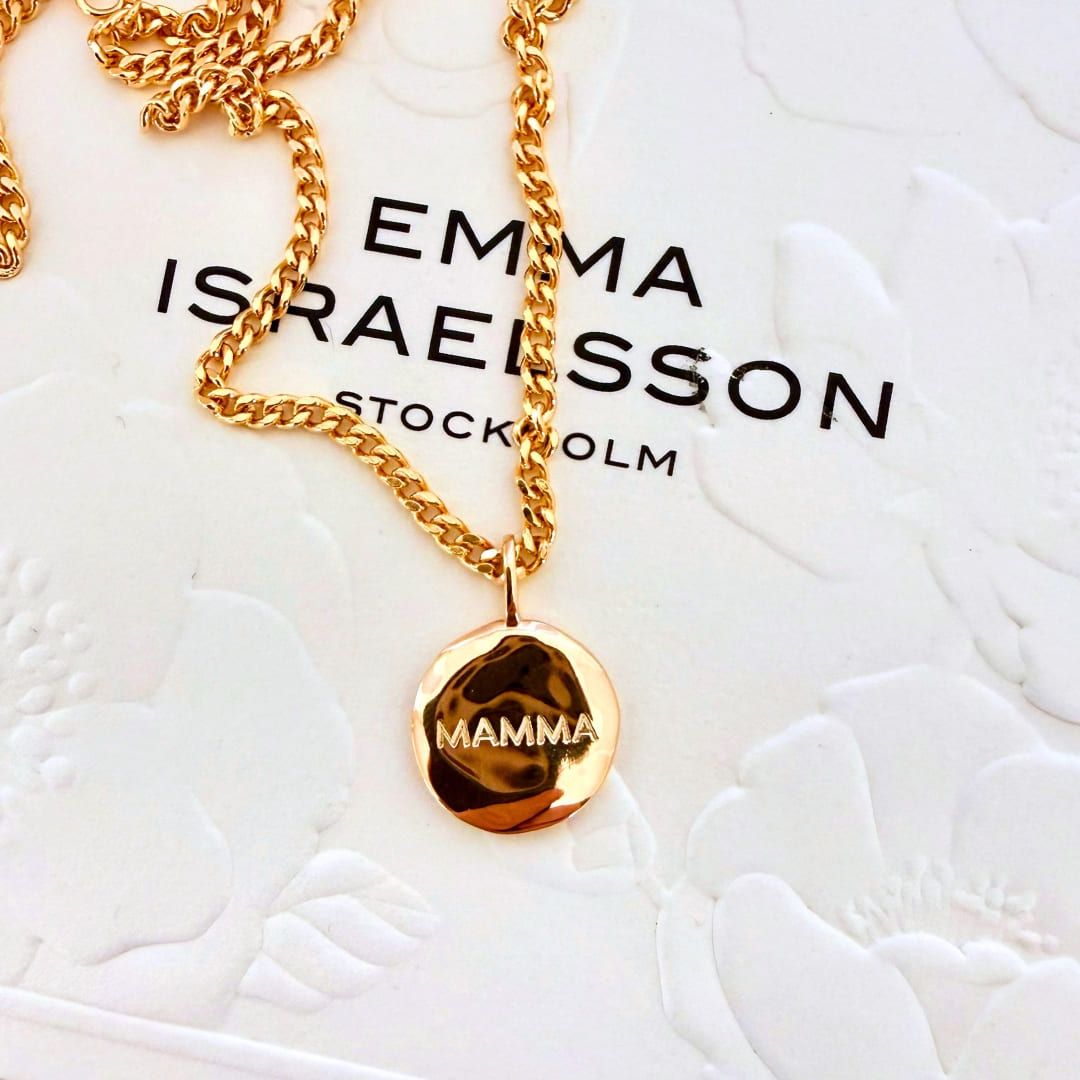 Mynt med ojämn yta i guld med graveringen MAMMA