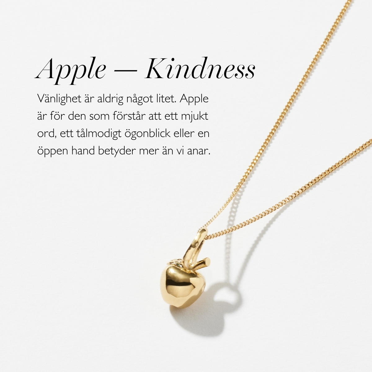 Ett silverhalsband med en berlock i form av ett äpple, med kvist och blad