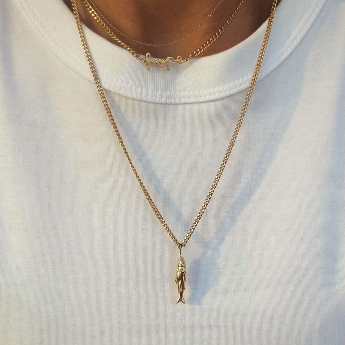 Silverhalsband med en berlock i form av en fisk, med ögon i vit cz-sten.