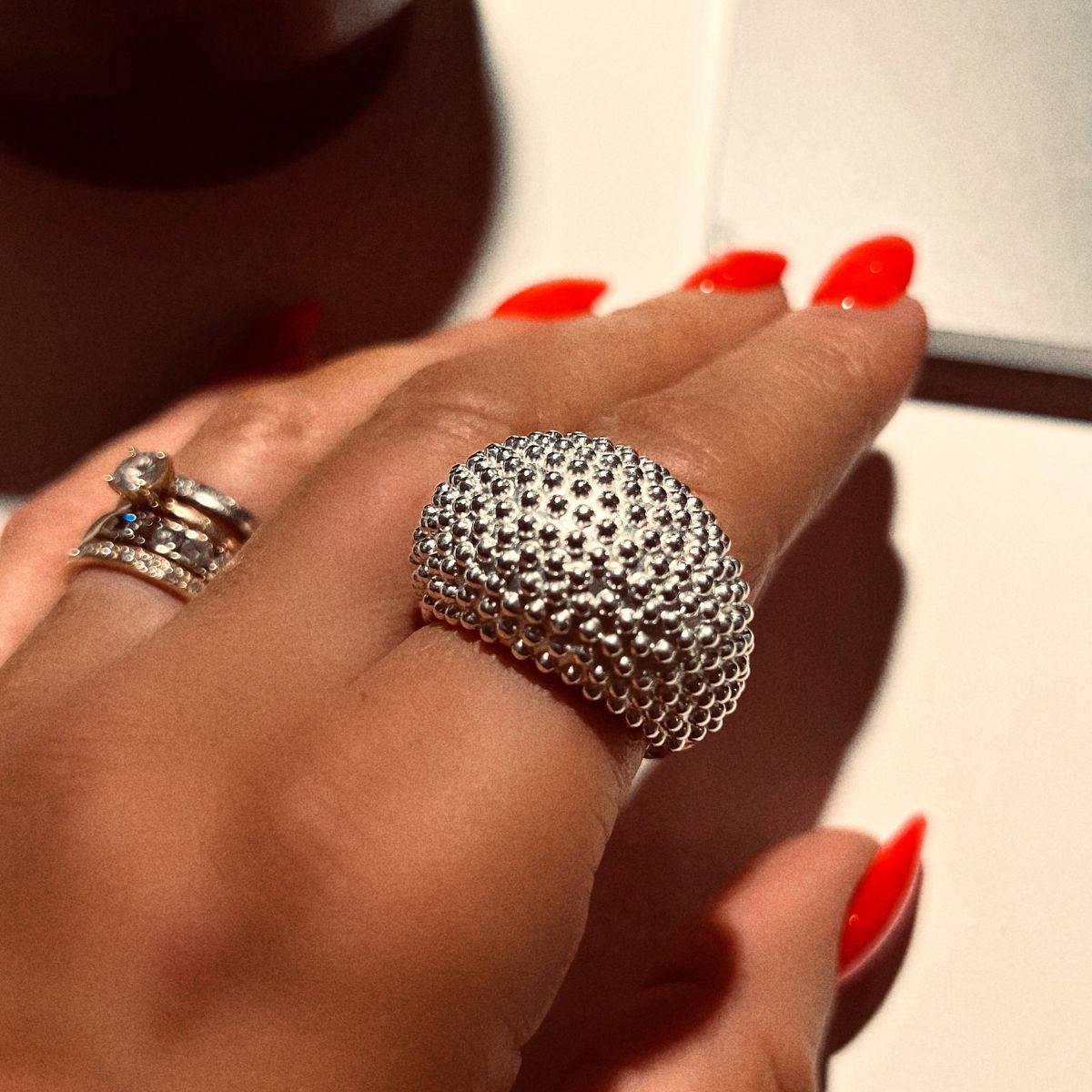 En cocktailring med små kulor på framsidan i silver