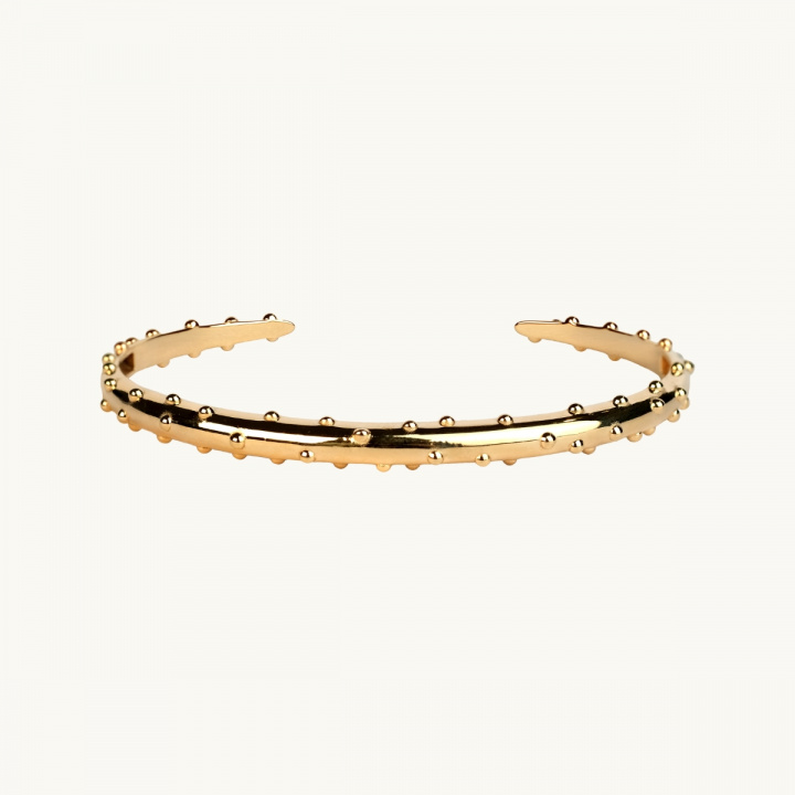 Ett högpolerat armband med en prickar på i guldförgylld mässing