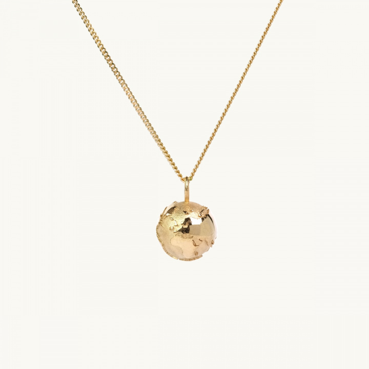 Ett halsband med en berlock i form av en jordglob i guld 