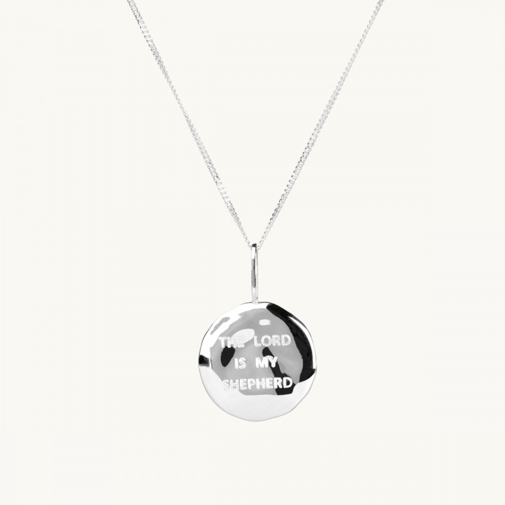 Halsband med ett silvermynt med oregelbunden yta och graveringen the lord is my shepherd