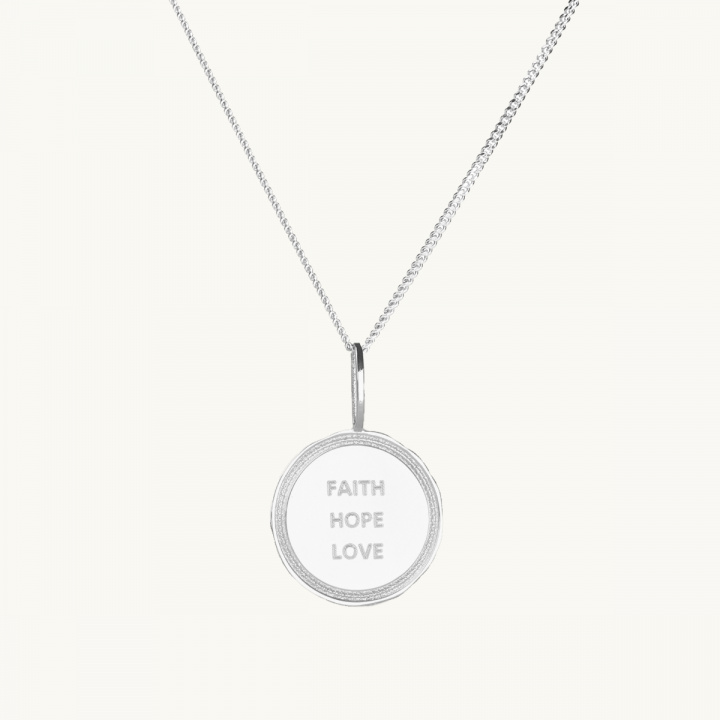 Ett mynt i silver med texten faith, hope, love