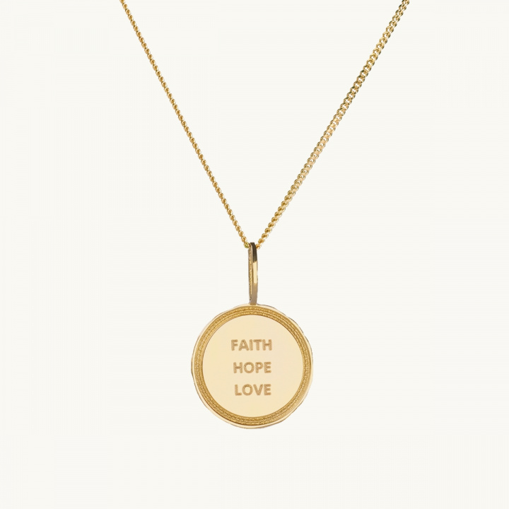 Ett mynt i gold med texten faith, hope, love