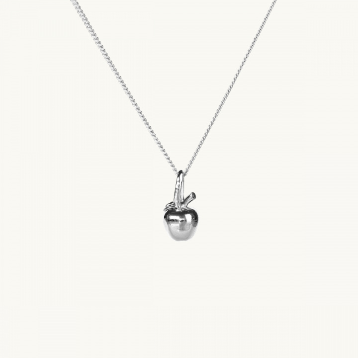 Ett silverhalsband med en berlock i form av ett äpple, med kvist och blad