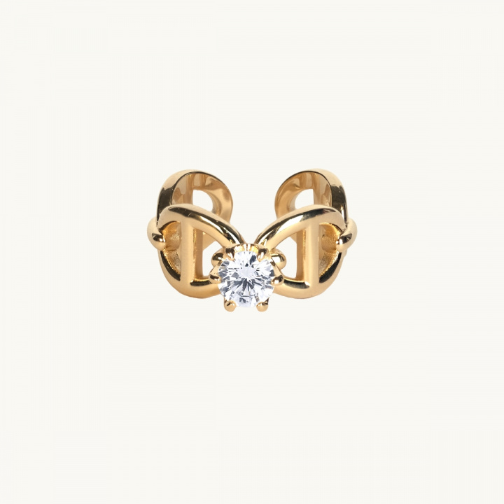 En guldring med ankarmönster med en vit diamant